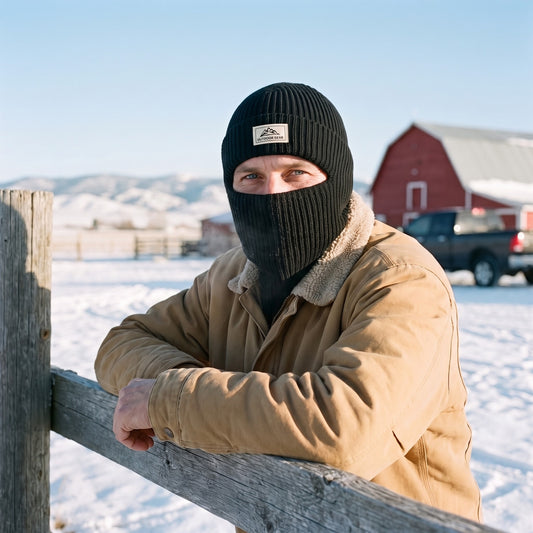 Balaclava - man at a snowy Montana ranch fence wearing the black 2-in-1 knit beanie pulled down as a full face and neck cover