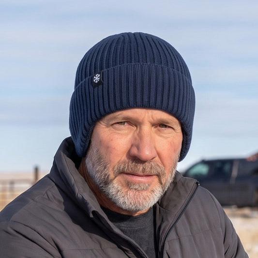 Winter beanie with ear flaps worn by a man closing a ranch gate on a cold windy day in Wyoming